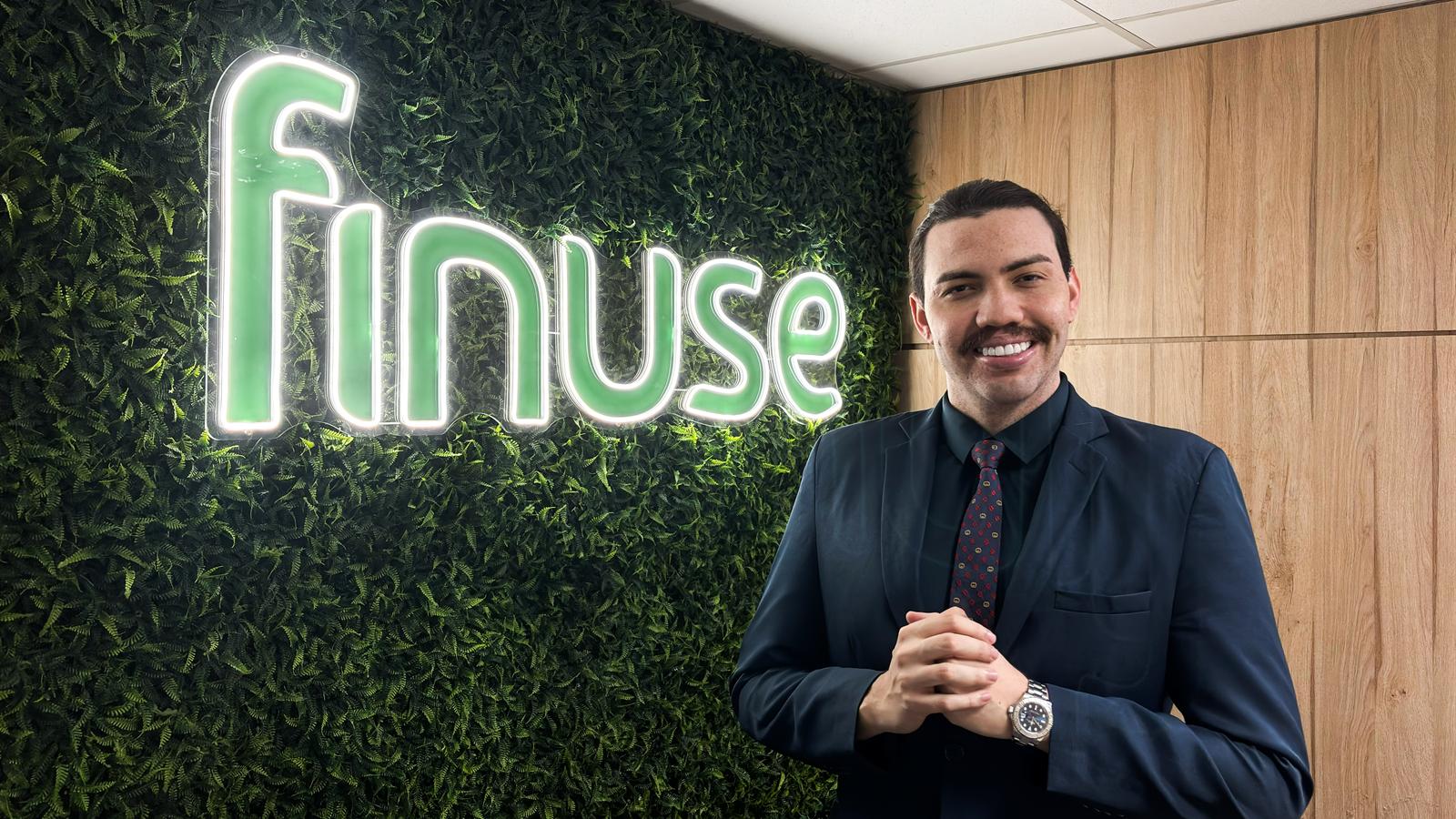 Hugo Dantas na Finuse, diante do letreiro de neon